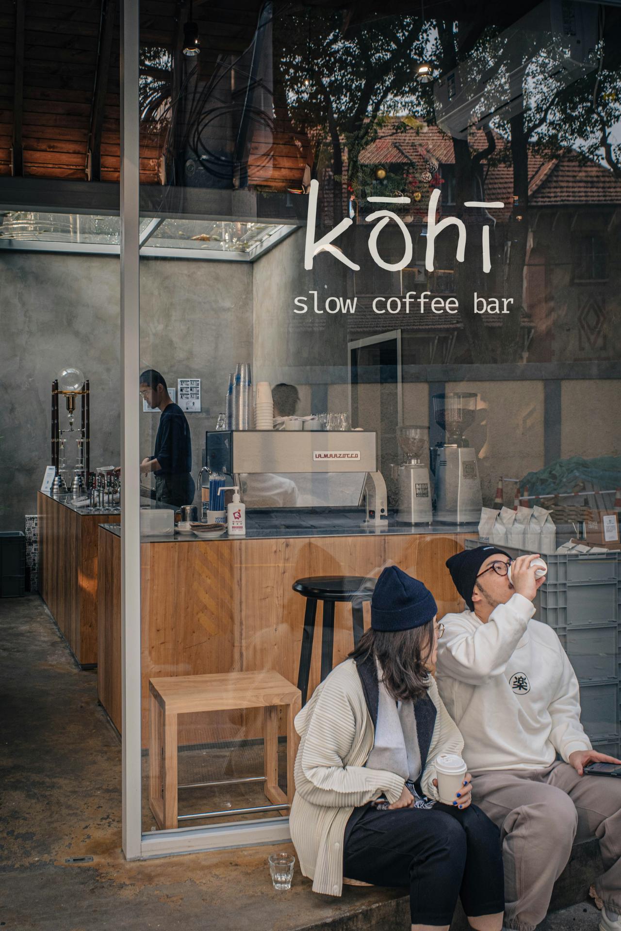 Kohi slow coffee bar exterior with customers seated outside and visible interior branding