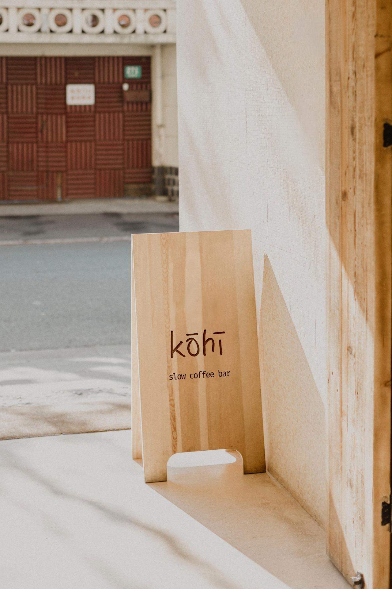 Kohi slow coffee bar wooden sidewalk signage board with minimalist branding