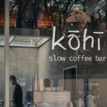 Kohi slow coffee bar window signage with interior café view and customers outside