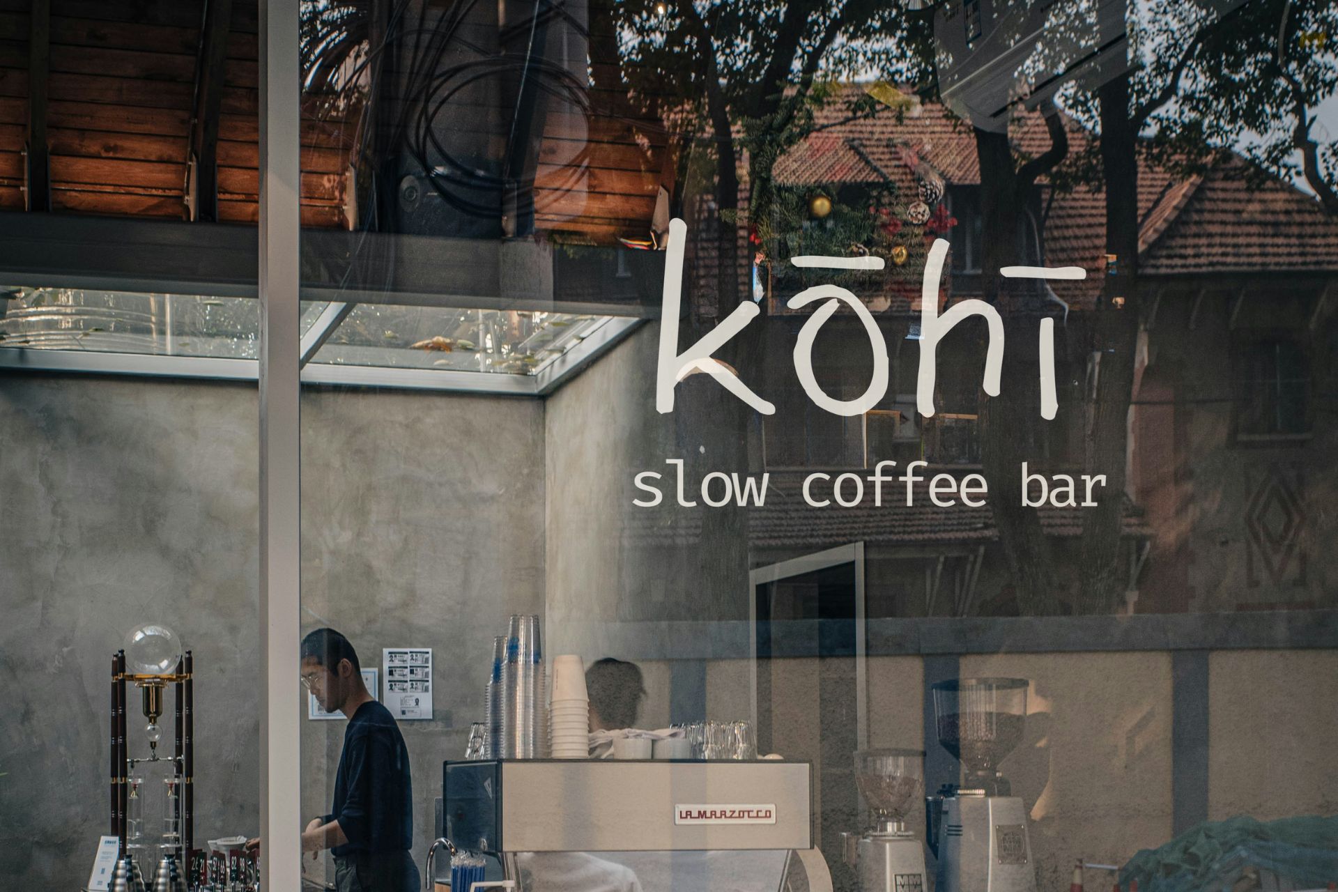 Kohi slow coffee bar window signage with interior café view and customers outside