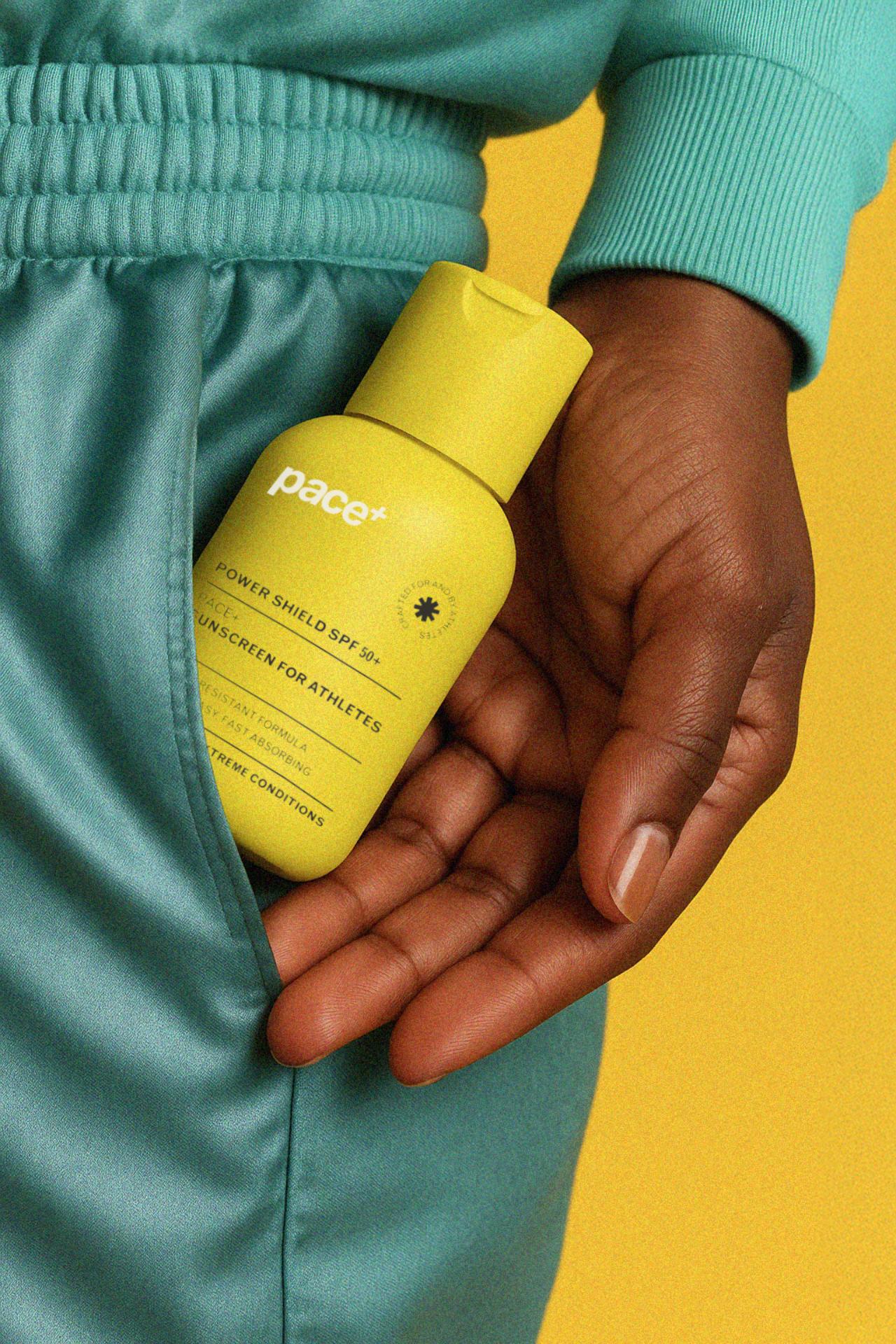 Athlete holding Pace+ sunscreen bottle demonstrating lifestyle sport skincare branding