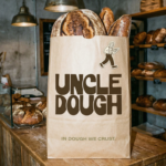 Uncle Dough bakery paper bag packaging with bold typography and illustrated baker logo