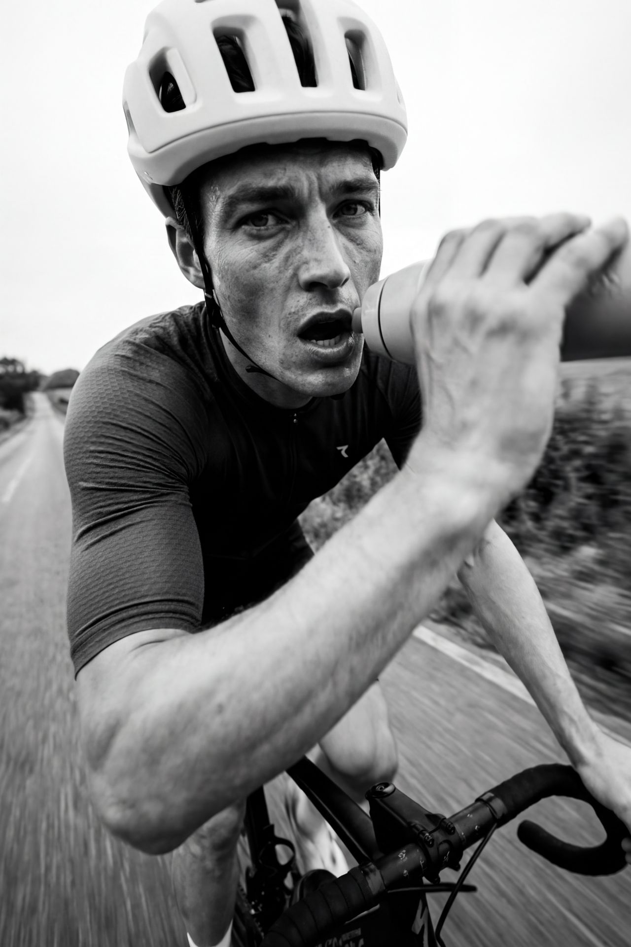 AI-generated road cyclist riding fast in city holding water bottle with blurred motion